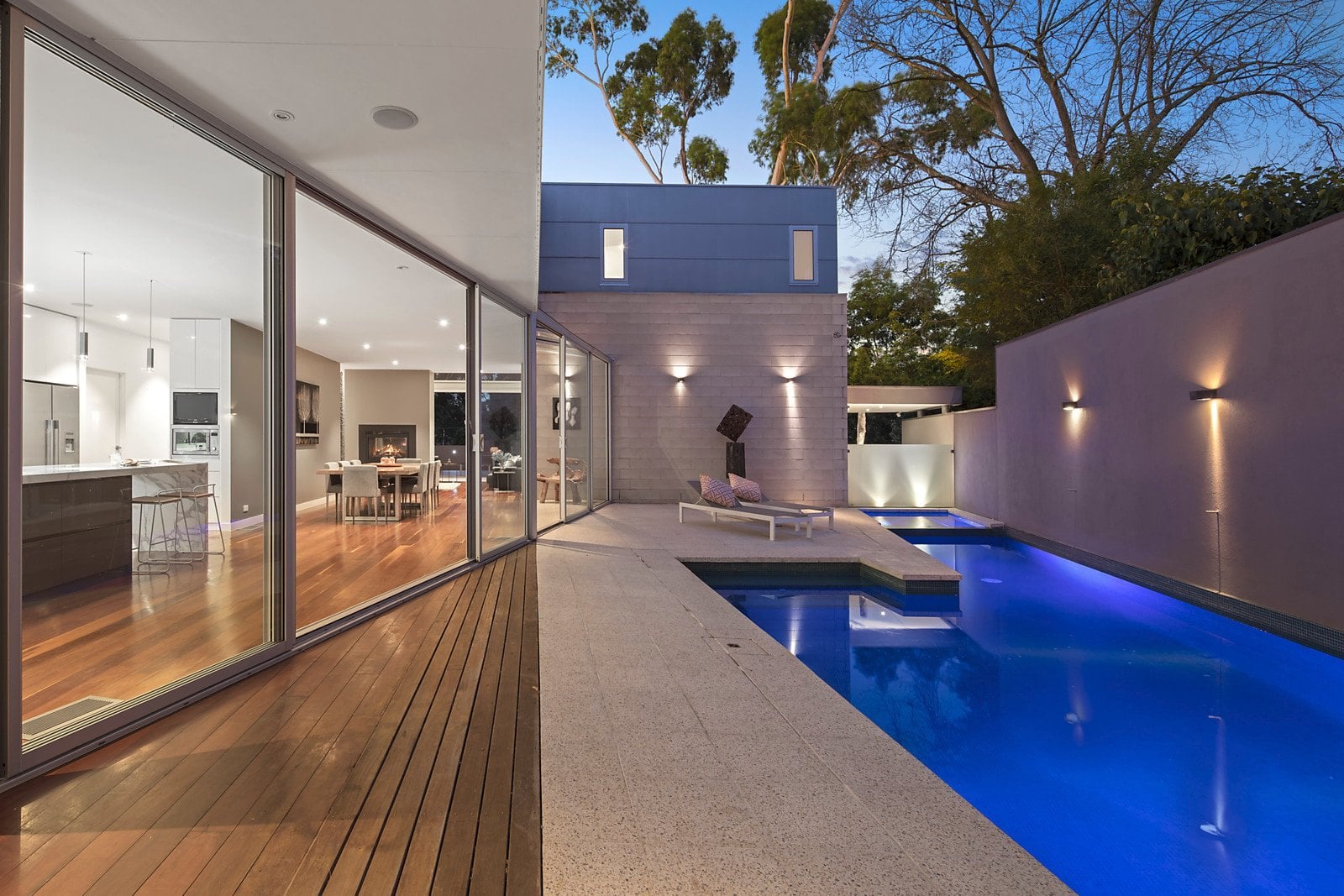 A new home in Eaglemont at dusk: the living room opening onto the terrace, and the pool along the glazing