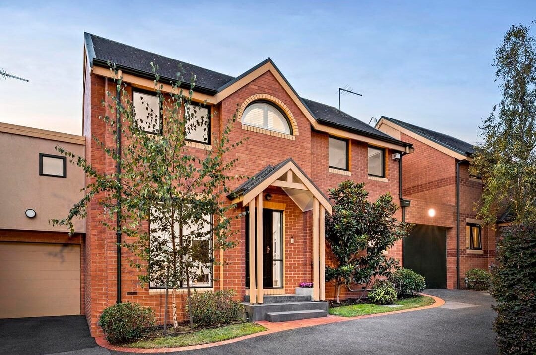 Red-brick townhouse with an arched window at dusk, Ivanhoe